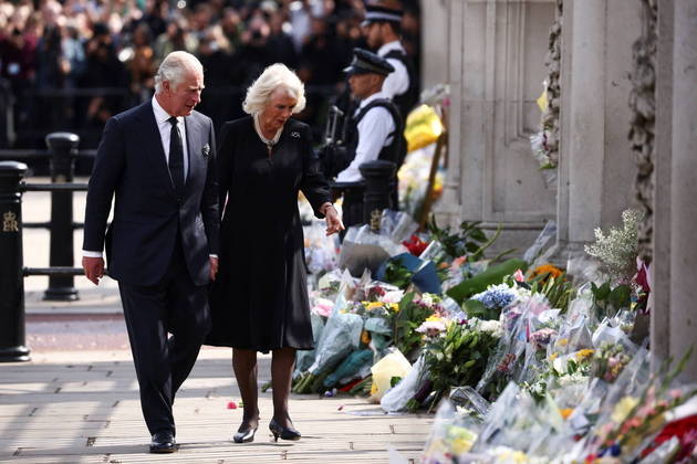 O rei do Reino Unido, Charles 3º, e a rainha consorte, Camilla, caminham perto da grade do Palácio de Buckingham e observam as homenagens que os súditos deixaram para a rainha Elizabeth 2ª, que morreu na última quinta-feira (8)