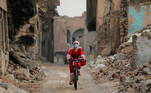 5 - An Iraqi woman, dressed as Santa claus, rides her bicycle, amid the spread of the coronavirus disease (COVID-19), in the old city of Mosul, Iraq, December 18, 2020. Picture taken December 18, 2020. REUTERS/Abdullah Rashid TPX IMAGES OF THE DAY