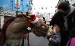 4 - Two-year-old Sofia Fox is nuzzled by a donkey wearing a Santa hat in a shopping street amid the spread of the coronavirus disease (COVID-19) pandemic, in Galway, Ireland, December 22, 2020. REUTERS/Clodagh Kilcoyne TPX IMAGES OF THE DAY