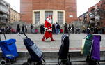 1 - 'Payasito', a performer dressed as Santa Claus, walks to entertain children as low income families queue to receive food given out by the NGO Madrina Foundation amid the coronavirus disease (COVID-19) outbreak, in Madrid, Spain December 24, 2020. REUTERS/Susana Vera TPX IMAGES OF THE DAY