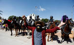 Em Goiânia, manifestante posa de máscara com dizeres contra o presidente, em frente à cavalaria