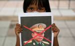 A girl holds a picture of Myanmar's army chief Min Aung Hlaing with his face crossed out as Myanmar citizens protest against the military coup in Myanmar outside United Nations venue in Bangkok, Thailand February 6, 2021. REUTERS/Chalinee Thirasupa
