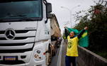 A man shouts while he holds up a Brazilian flag while standing next to a truck, as supporters of Brazil's President Jair Bolsonaro partially block the Castelo Branco highway during a protest over Bolsonaro's defeat in the presidential run-off election, in Barueri, Brazil November 2, 2022. REUTERS/Amanda Perobelli
