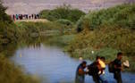 Vários migrantes atravessam o Rio Bravo (chamado de Rio Grande, nos Estados Unidos), que às vezes tem fluxo mais complicado para os estrangeiros. Os migrantes eventualmente carregam seus pertences para o alto, e a água chega ao pescoço de vários deles
