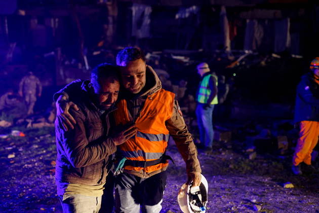 Volunteers share an emotional moment as they take part in a rescue operation following an earthquake in Hatay, Turkey February 8, 2023. REUTERS/Kemal Aslan