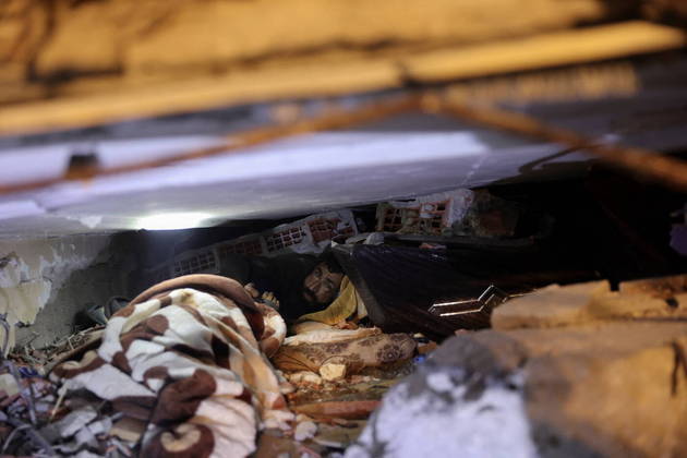 Abdulalim Muaini looks out from under the rubble in the aftermath of a deadly earthquake in Hatay, Turkey, February 8, 2023. REUTERS/Umit Bektas
