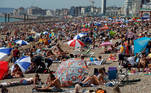 People enjoy the sunny weather at a beach in Brighton, Britain July 31, 2020. REUTERS/Paul Childs