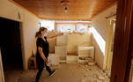 A local resident walks inside her damaged house following an earthquake in the village of Damasi, in central Greece, March 3, 2021. REUTERS/Thanos Floulis