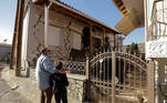 People look at a damaged house following an earthquake in the village of Damasi, in central Greece, March 3, 2021. REUTERS/Thanos Floulis