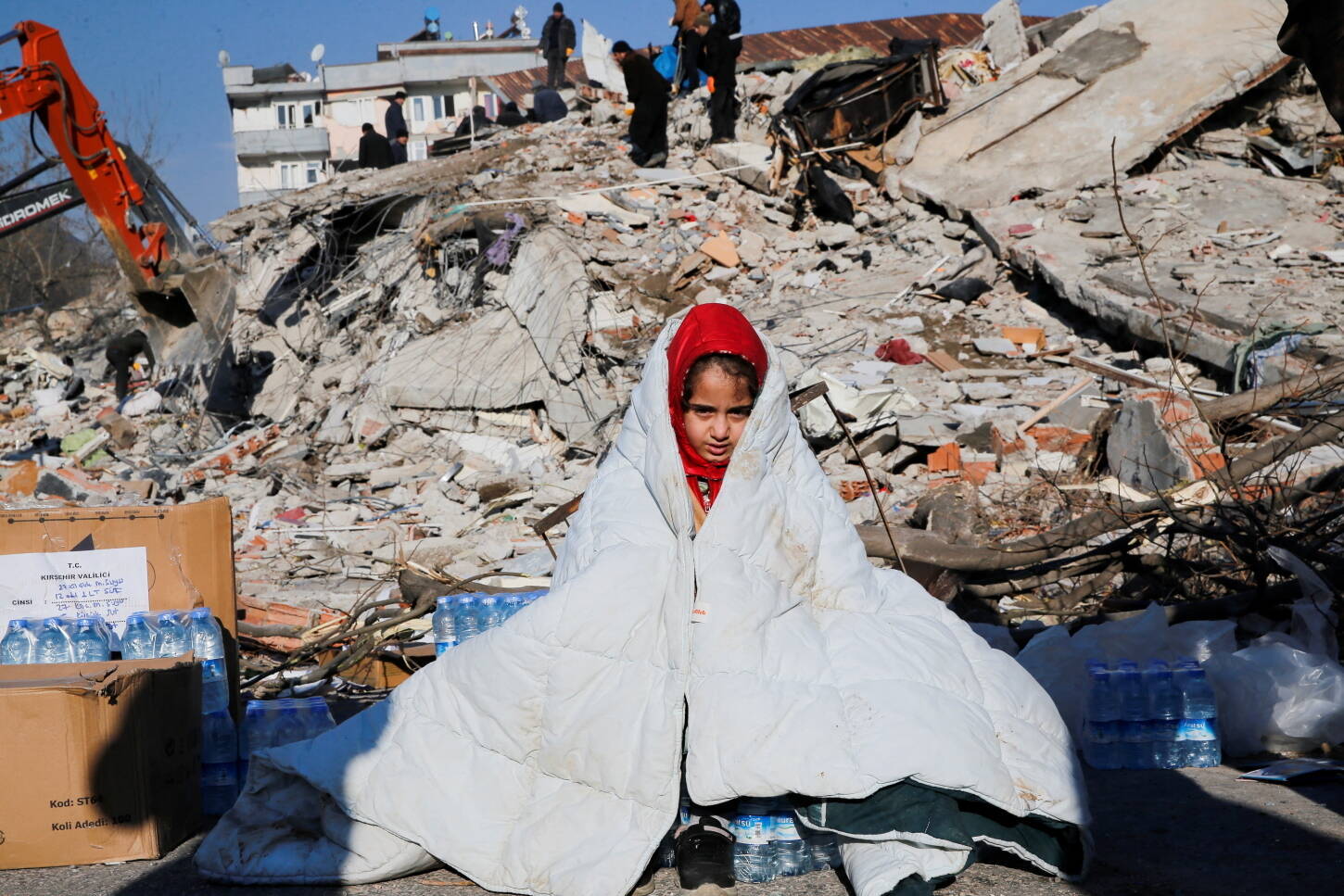 A girl sits near the site of a collapsed building following an earthquake in Kahramanmaras, Turkey February 8, 2023. REUTERS/Dilara Senkaya
