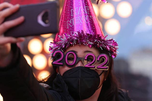 Teresa Hui, 40, of Brooklyn, wears 2022 numeral glasses and a face mask in Times Square ahead of New Year's Eve celebrations as the Omicron coronavirus variant continues to spread in Manhattan, New York City, U.S., December 20, 2021. REUTERS/Andrew Kelly