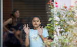 Sobrevivente ao atirador de Uvalde, no Texas, uma garota observa através de janela de vidro do centro comunitário para onde as crianças foram levadas depois do ataque
