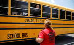 As crianças foram retiradas do local em um ônibus escolar. Na imagem, uma funcionária da escola conversa com a mãe de um dos alunos pela janela do coletivo