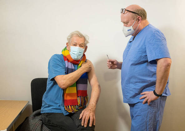 ATTENTION EDITORS - CAPTION CORRECTION FOR RC2ZOK95N1BF. WE ARE SORRY FOR ANY INCONVENIENCE CAUSED. REUTERS. REFILE - CORRECTING DATE Actor Ian McKellen speaks with GP Dr Phil Bennett-Richards as he receives the Pfizer-BioNTech COVID-19 vaccine at the Arts Research Centre, Queen Mary University Hospital, in London, Britain December 16, 2020. Jeff Moore/Handout via REUTERS ATTENTION EDITORS - THIS IMAGE WAS PROVIDED BY A THIRD PARTY. NO RESALES. NO ARCHIVES. MANDATORY CREDIT. TEMPLATE OUT.