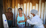 Francisca do Carmo receives the AstraZeneca/Oxford vaccine for the coronavirus disease (COVID-19) by a municipal health worker, as her husband Raimundo do Carmo looks on, along the Solimoes river banks, where Ribeirinhos (river dwellers) live, in Manacapuru, Amazonas state, Brazil, February 1, 2021. Picture taken February 1, 2021. REUTERS/Bruno Kelly