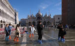 People walk through a flooded St. Mark's Square during seasonally high water in Venice, Italy November 5, 2021. REUTERS/Manuel Silvestri