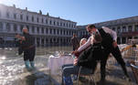 Visitors are served at a cafe in a flooded St. Mark's Square during seasonally high water in Venice, Italy November 5, 2021. REUTERS/Manuel Silvestri