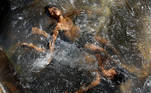 Boys cool themselves off in the waters of a tube well on a hot summer day at a field in New Delhi, India July 1, 2021. REUTERS/Adnan Abidi TPX IMAGES OF THE DAY