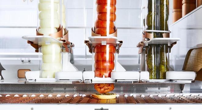 Robôs fazem de tudo: desde moer a carne e moldar os hambúrgueres até fatiar tomates, ralar queijo e colocar mostarda 