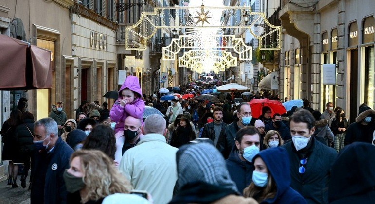 Pedestres usam máscaras enquanto caminham em rua comercial em Roma