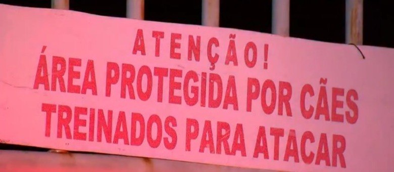 Placa na entrada do galpão, que fica no bairro Nova Cachoeirinha, avisa sobre perigo de invasão