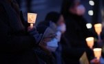 Pessoas protestam contra a invasão Russa à Ucrânia segurando velas em frente a embaixada da Rússia em Seul, na Coreia do Sul