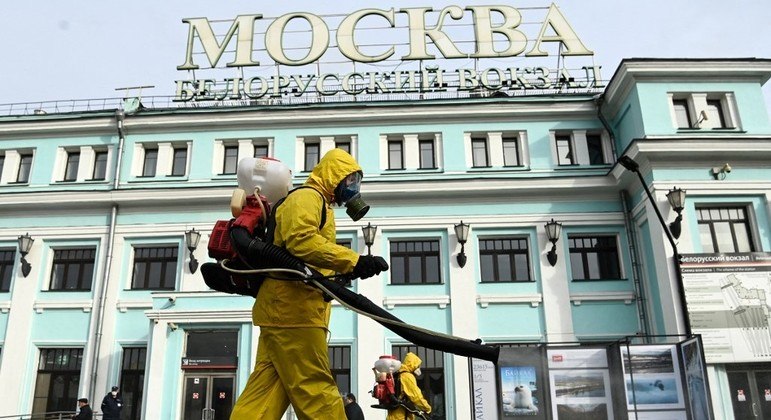 Militares usam equipamento de proteção e desinfetam a estação ferroviária de Belorussky, em Moscou, em meio à pandemia