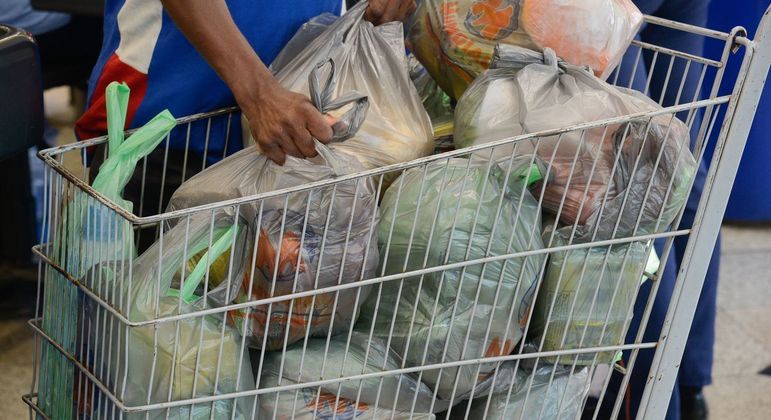Carrinho de supermercado com várias sacolas plásticas