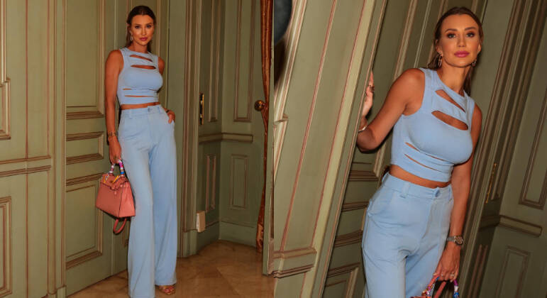 Na imagem anterior, laranja e amarelo combinavam por serem cores análogas no círculo cromático. Outra opção de mistura de cores é a de tons complementares, como azul e rosa. Neste look proposto por Ana, as duas cores básicas aparecem em uma variação pastel. Como as peças de roupa são do exato tom de azul, complementar o visual com um acessório rosa só acrescenta personalidade