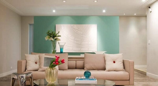 Sala de estar clean com parede verde e Spot de LED