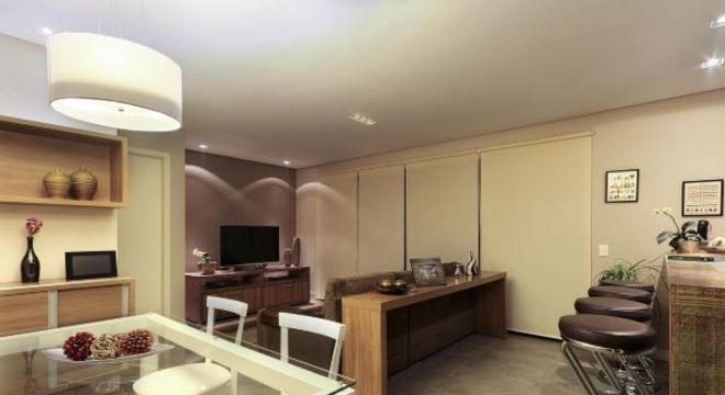 Sala de estar com cozinha integrada com cores neutras