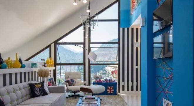 Sala de estar com parede azul e iluminada