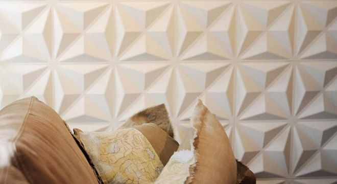 Sala de estar com parede revestida com placa de gesso 3D com desenho triangular