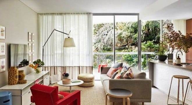 Sala de estar gourmet com poltrona vermelha e tapete sisal