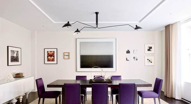 sala de jantar com cadeiras roxas e quadro grande