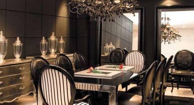 Sala de jantar sofisticada com lustre colonial e cadeira medalhão