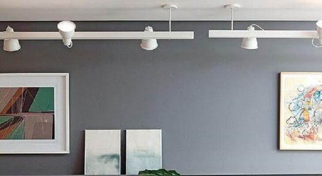 sala decorada com parede cinza e trilho de luz branco
