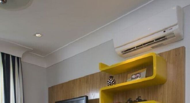 sala decorada com rack com painel e nichos amarelos