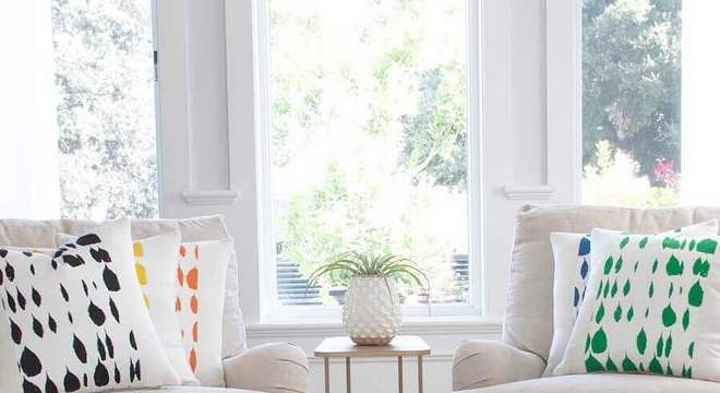 sala toda branca decorada com almofadas coloridas 