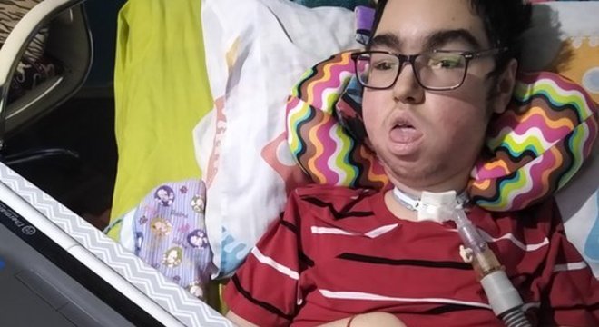 "Santiago gosta muito do computador, ele é muito inteligente." O adolescente usa um trackball, um mouse com uma bola, para escrever no computador e aprendeu inglês "no Google e no YouTube" 
