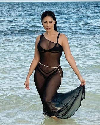 Nas gravações, ela também posou saindo do mar com o mesmo biquíni preto, mas com uma saída de praia preta transparente e uma corrente de cintura por cima