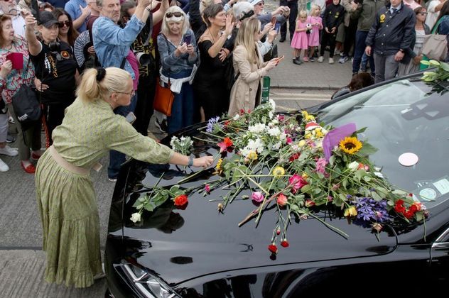Uma fã coloca flores sobre o carro que leva o corpo de Sinéad O'Connor até o cemitério. Segundo informações da empresa britânica, o sepultamento teve a presença de famosos como Bono e The Edge, do U2, e também do cantor Bob Geldof. Michael D. Higgins, presidente irlandês, também participou do evento