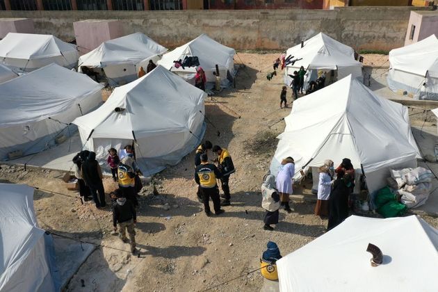 Os socorristas conhecidos como Capacetes Brancos distribuem medicamentos e alimentos a vítimas do terremoto na cidade de Killi, na Síria, neste sábado (11)