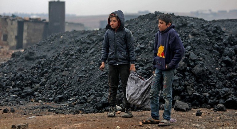 Meninos coletam materiais em ferro-velho na cidade de Al Bab, na Síria
