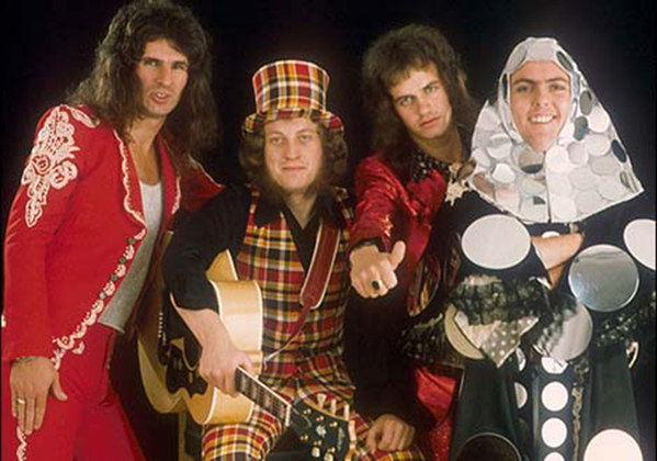 Slade - Icônica banda de Glam Rock do Reino Unido que fez sucesso nos anos 60 e 70, famosa por suas apresentações sempre divertidas e um visual muito colorido e alegre, seus maiores sucessos foram as músicas 