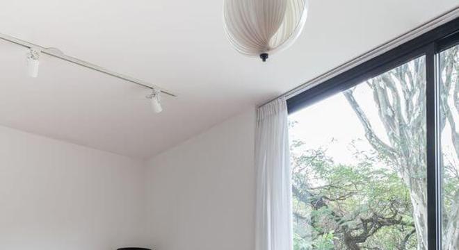 Sofá colorido cor de rosa claro no mesmo tom que o tapete