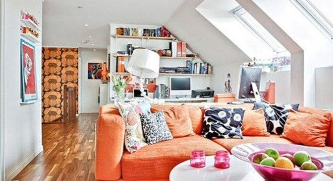 Sofá colorido laranja com almofadas estampadas