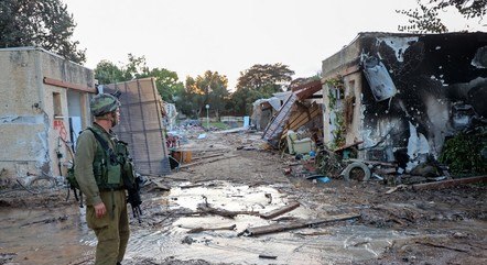 Soldado israelense caminha por área destruída em Gaza