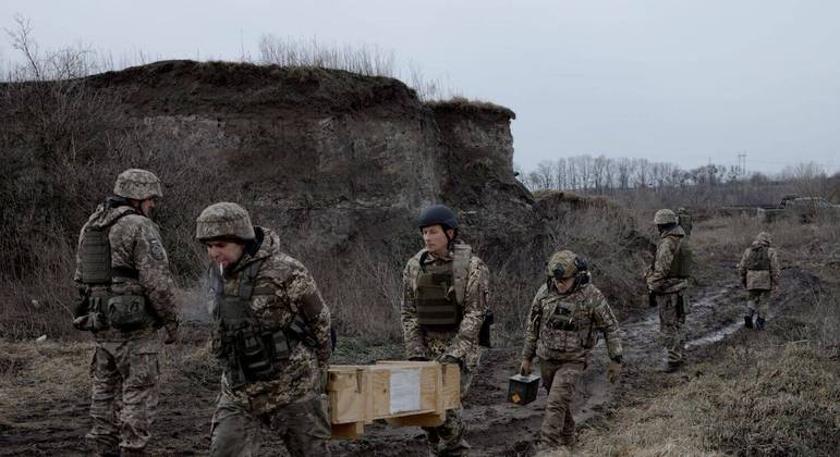  Soldados da defesa territorial ucraniana carregam armas e munições em preparação para uma sessão de treinamento perto de Kiev, capital da Ucrânia