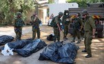 Soldados retiram corpos do kibutz de Kfar Aza, em Israel